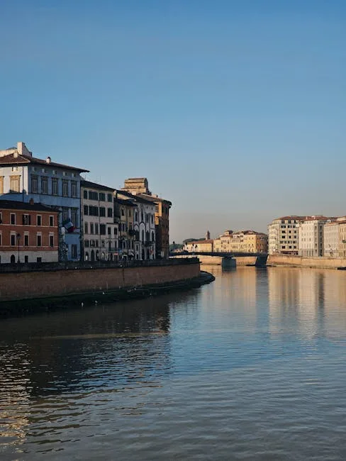 Nabrzeże rzeki Arno w Pizie z historycznymi kamienicami i mostem