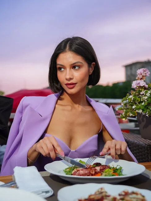 Kobieta w eleganckiej sukience je owoce morza na tarasie w Pizie