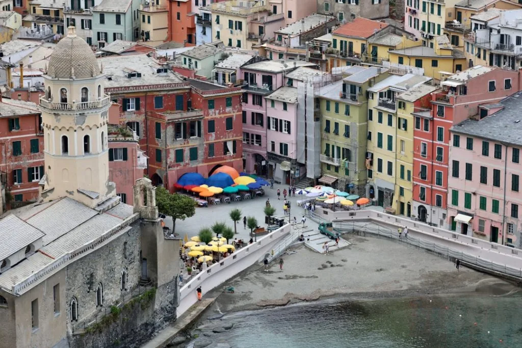 Kolorowy plac w Vernazzie w Cinque Terre z parasolami nad nadmorską plażą