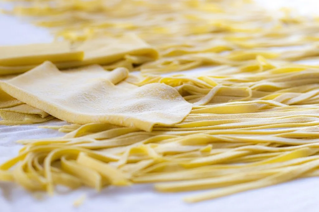 Tradycyjny włoski makaron tagliatelle suszący się na stole