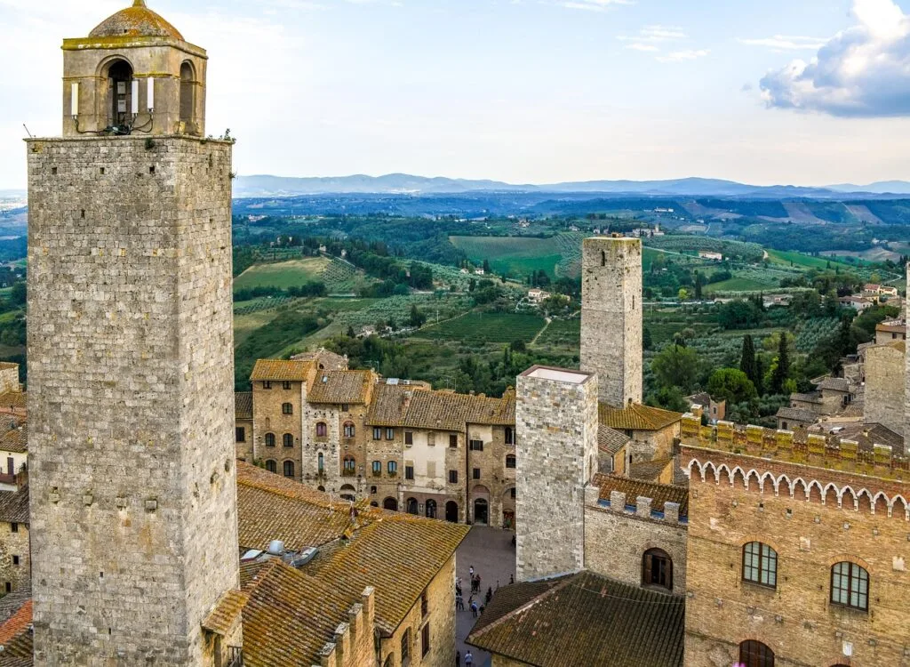 Widok z wieży na dachy i wieże San Gimignano oraz pagórki