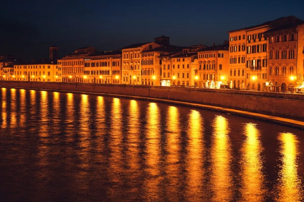 Nabrzeże Arno w Pizie o nocnej porze z rozświetlonymi fasadami